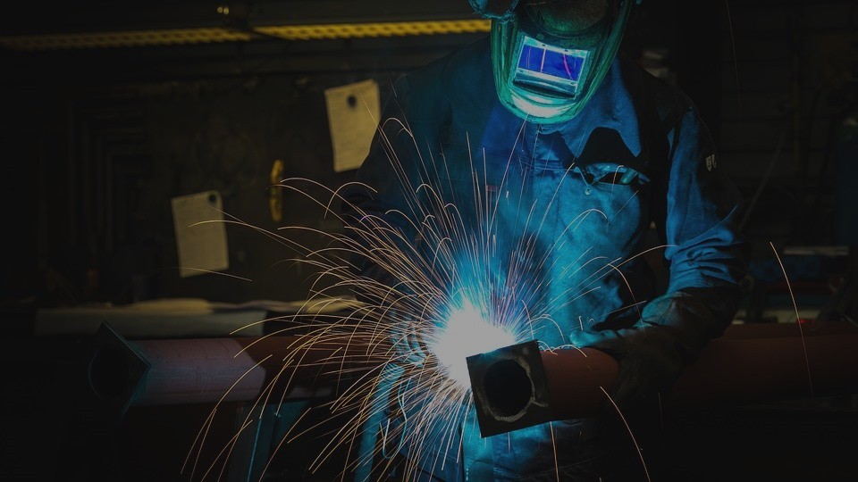 Soldador con toda la protección puesta: guantes, cascos, mono de trabajo...