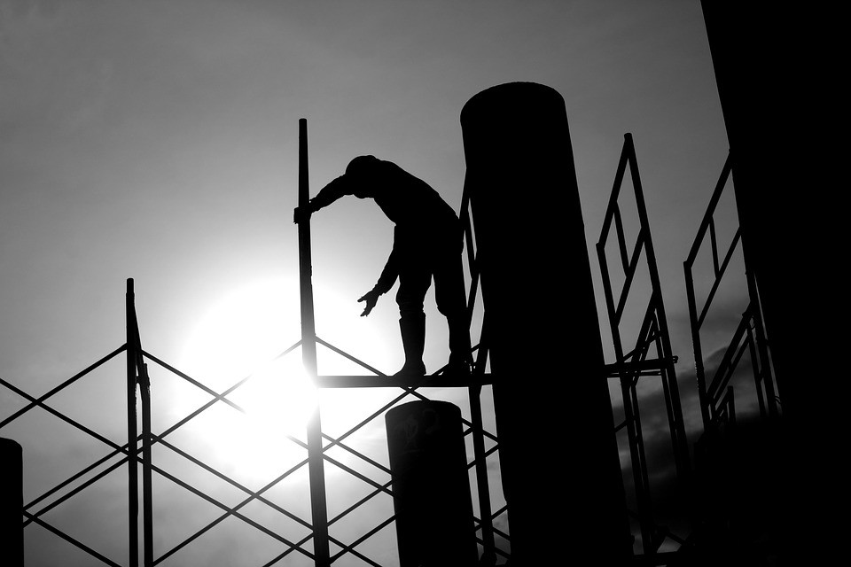 Operario de la construcción subido a un andamio con riesgo de caerse.