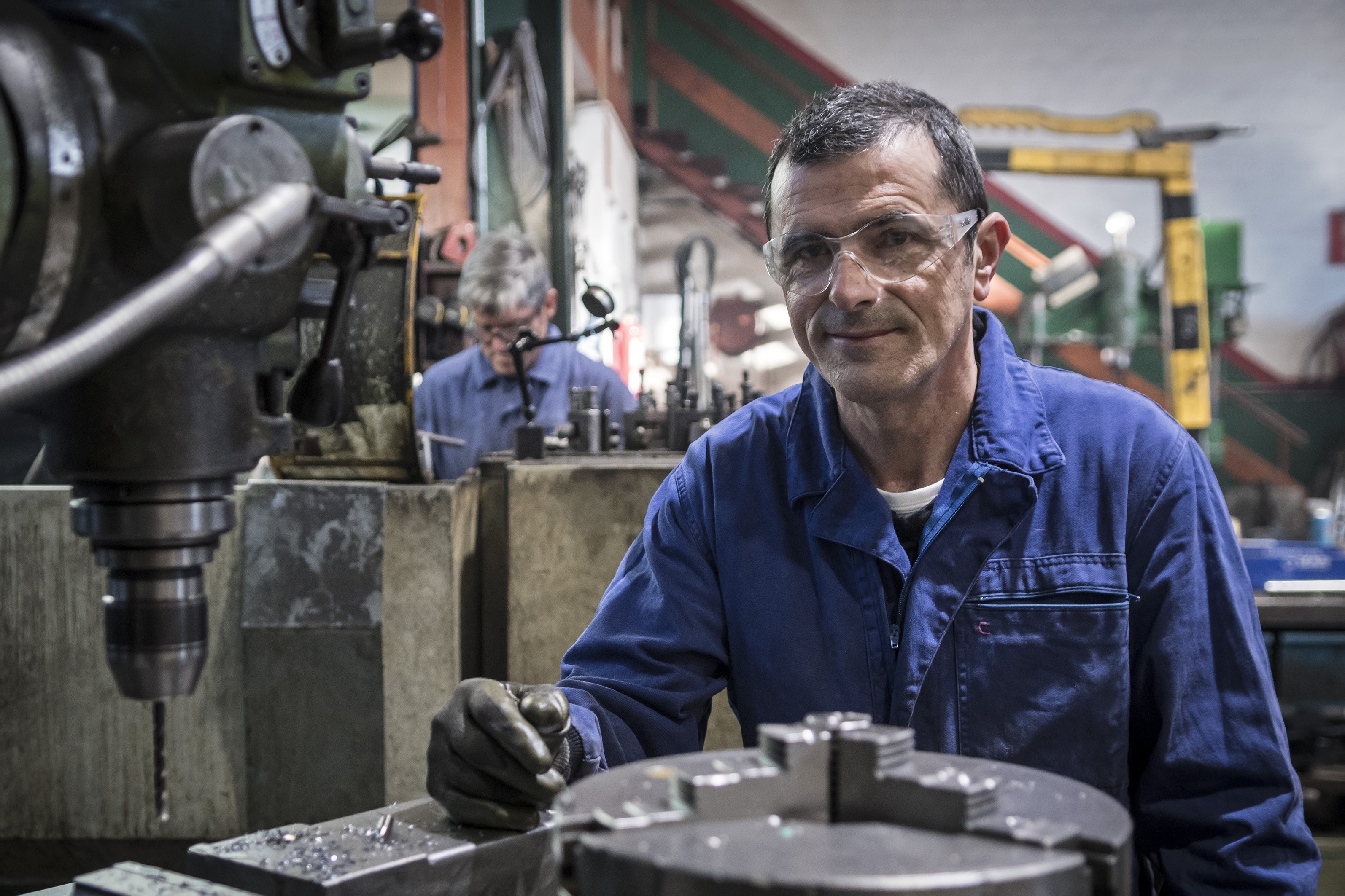 Carlos Remiro López, tornero fresador en el taller con su compañero de fondo