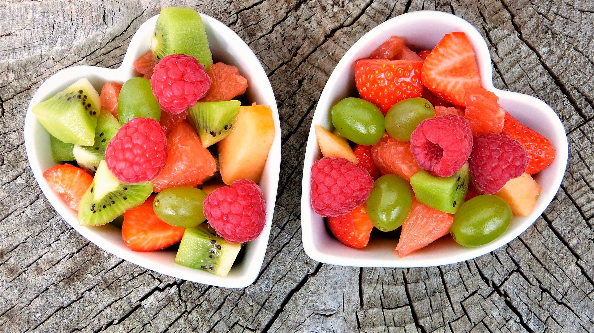 Cuencos en forma de corazon con fruta saludable dentro