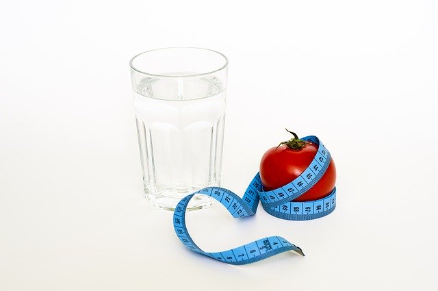 Imagen de un vaso de agua, una manzana y un metro