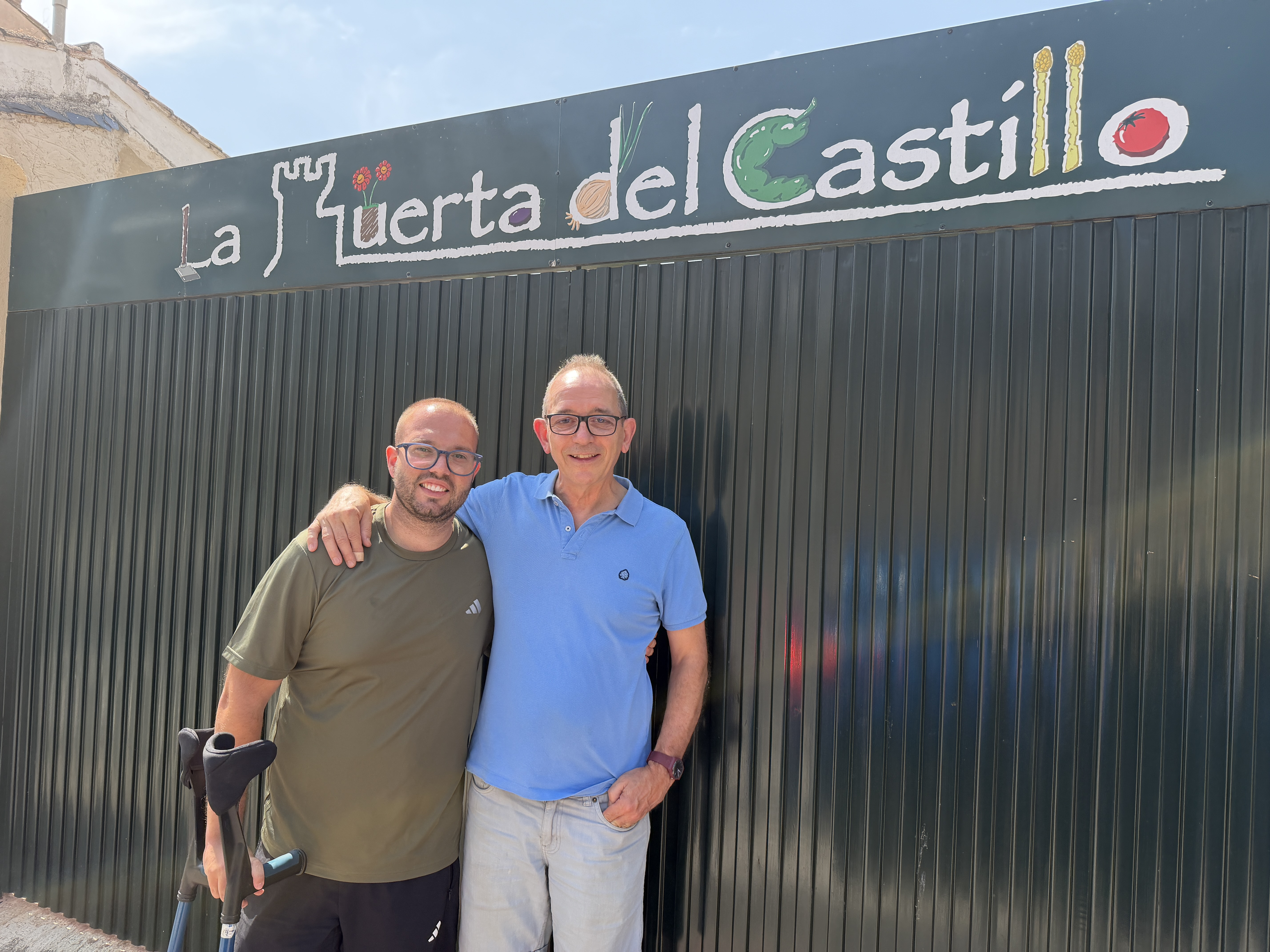 El director y un exalumno posan frente a la huerta de la Fundación El Castillo, donde cultivan los alimentos que después usan en sus talleres de cocina